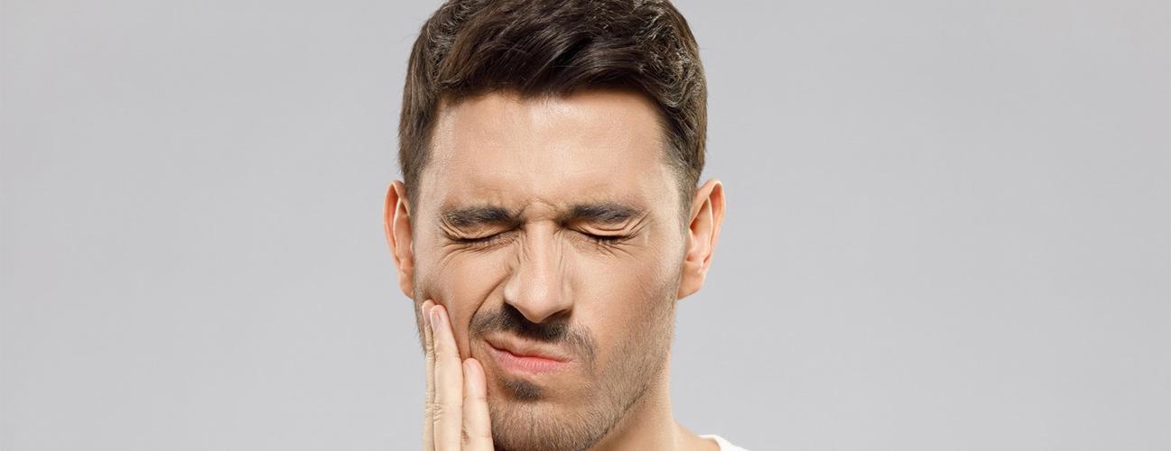 一名男子因牙齿敏感而感到不适. 